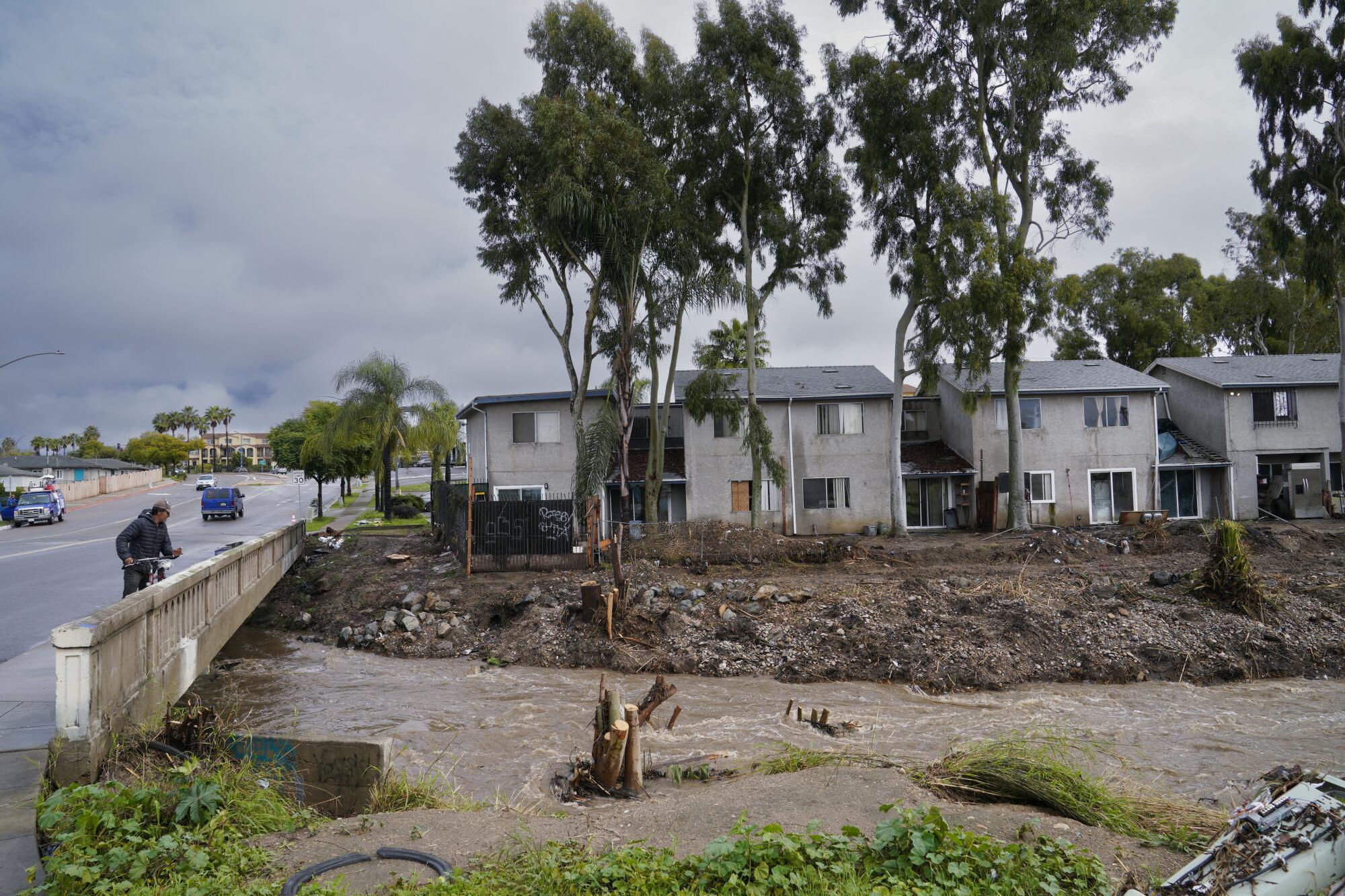 Aman stops to look at the damage to nearby apartments on National Avenue.