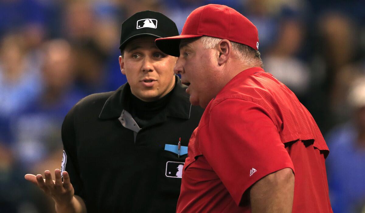 Angels Manager Mike Scioscia, right, talks with home plate umpire Adam Hamari during the fourth inning against the Kansas City Royals on Monday.