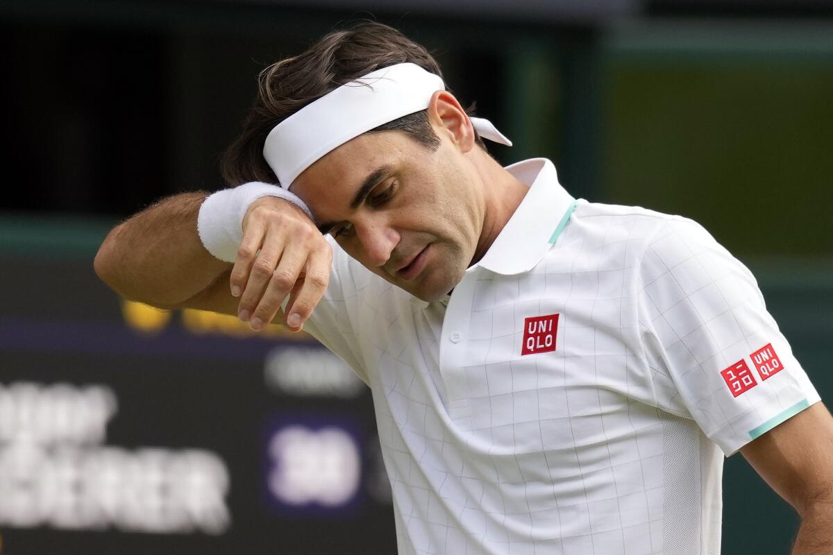 ARCHIVO - En imagen de archivo del 7 de julio de 2021, el suizo Roger Federer se limpia el sudor durante un partido.