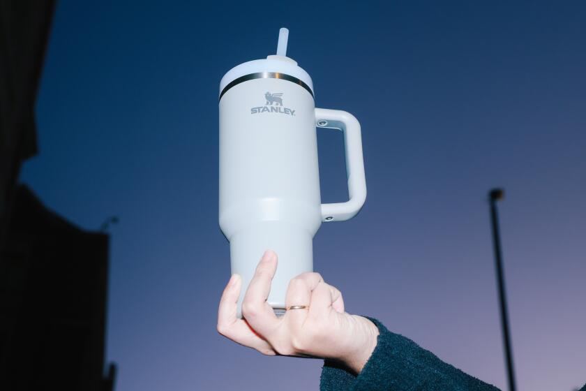 Los Angeles, CA - January 08: Hannah Gomez holds her Stanley Cup branded water bottle up high for a photograph at USC University Village on Monday, Jan. 8, 2024 in Los Angeles, CA. Gomez was surprised to realize how much attention her new bottle gave her. (Dania Maxwell / Los Angeles Times)