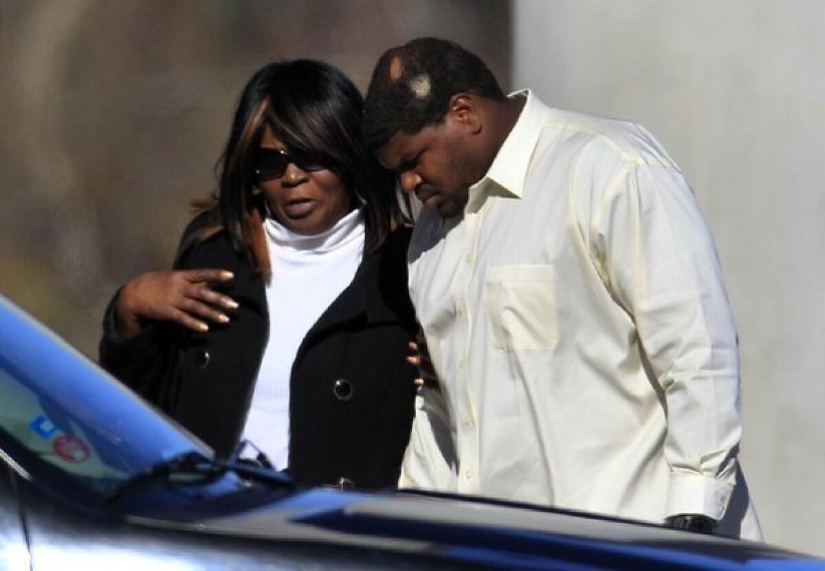 Dallas Cowboys football player Josh Brent, right, embraces an unidentified person at a memorial service Tuesday for teammate Jerry Brown.