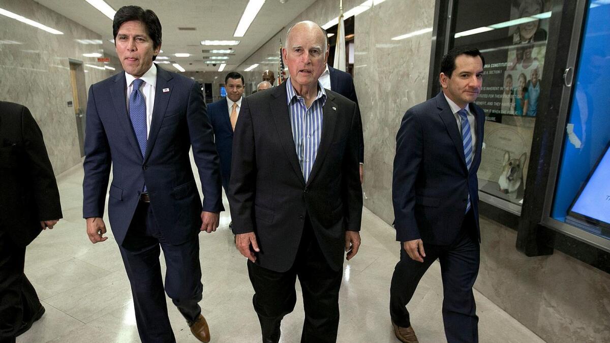 State Senate President Pro Tem Kevin de Leon (D-Los Angeles), Gov. Jerry Brown and Assembly Speaker Anthony Rendon (D-Paramount) walk through the Capitol.