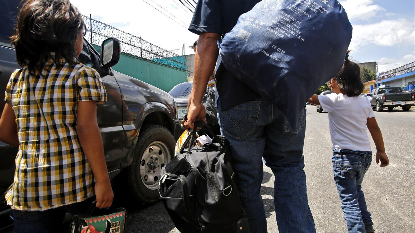With a Bible in a worn carrying case and clothes in a parachute bag, the Rodriguez family walks from a repatriation center in San Pedro Sula, Honduras, in July. They had been traveling to the United States when arrested and deported by border agents in Tapachula, Mexico. Like tens of thousands in this city, they tried to flee violence and poverty.