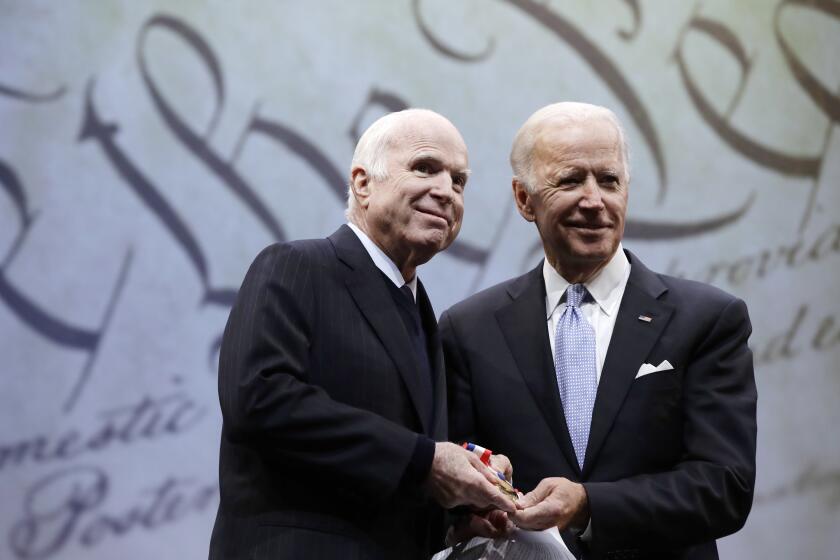 FILE - In this Oct. 16, 2017, file photo Sen. John McCain, R-Ariz., receives the Liberty Medal from Chair of the National Constitution Center's Board of Trustees, former Vice President Joe Biden, in Philadelphia. Cindy McCain is going to bat for Biden, lending her voice to a video set to air on Tuesday, Aug. 18, 2020 during the Democratic National Convention programming focused on Biden’s close friendship with her late husband, Sen. John McCain. (AP Photo/Matt Rourke, File)