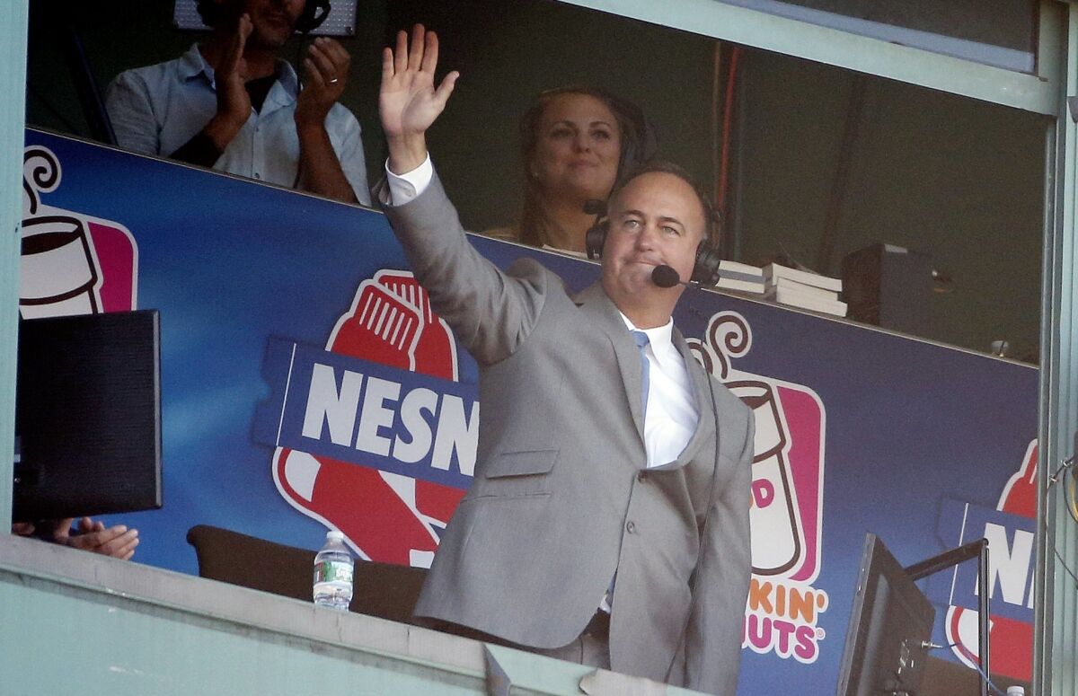 Sports announcer Don Orsillo waves from the broadcast booth following a video tribute during the eighth inning of a baseball game between the Boston Red Sox and the Baltimore Orioles in Boston, Sunday, Sept. 27, 2015. (AP Photo/Michael Dwyer)