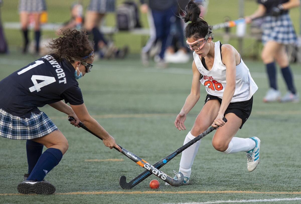 Newport Harbor's Zoey Gaddis and Huntington Beach's Anela Kaye battle for possession.