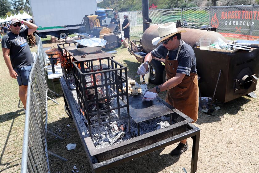 DANA POINT, CA - August 13: A pitmaster prepares food during the Heritage Barbecue Anniversary Pitmaster Invitational at Sea Terrace Community Park, on Saturday, August 13, 2022 in Dana Point, CA. (Kevin Chang / TimesOC)