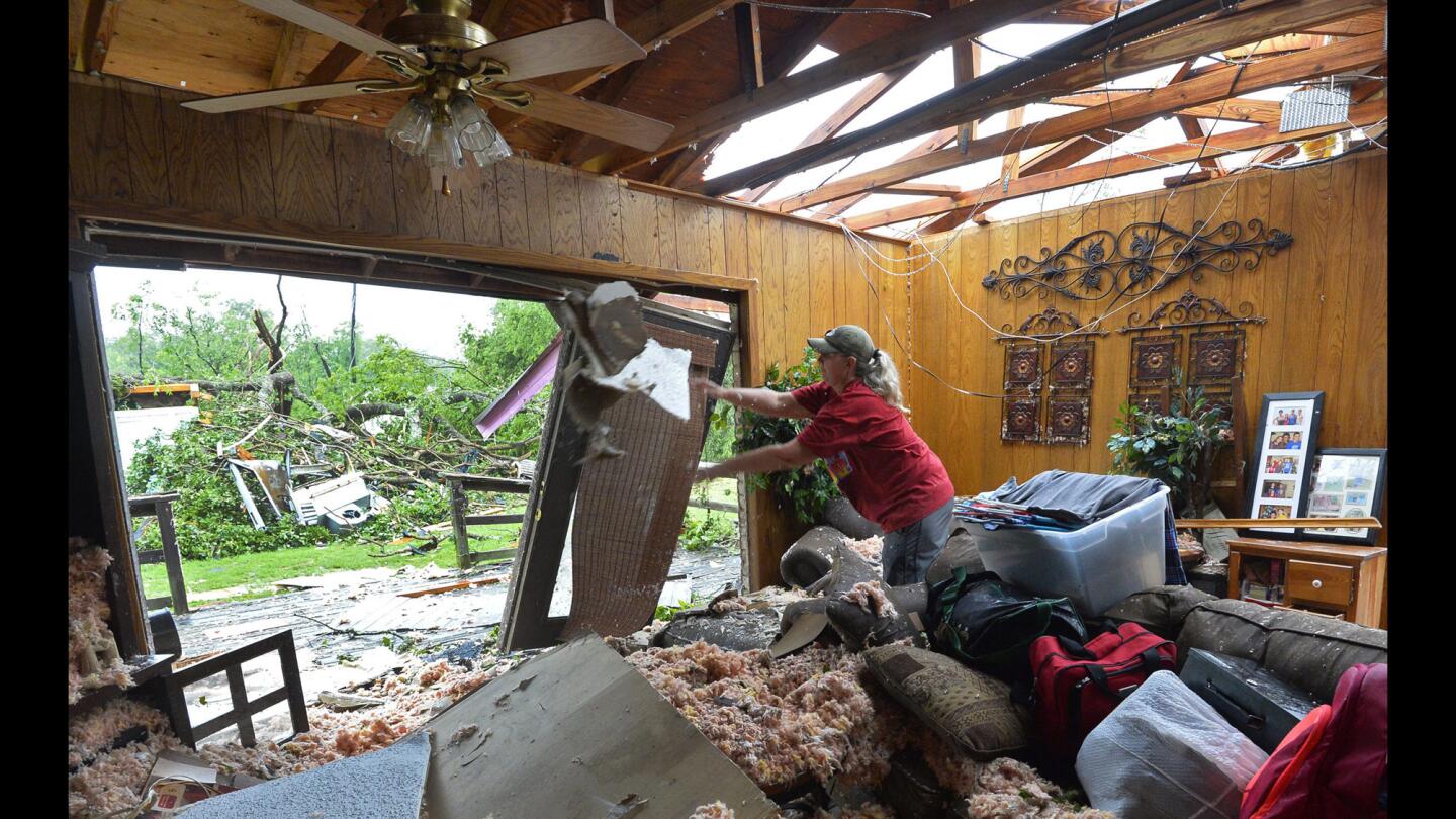 Christie Hulsey throws out pieces of the ceiling while trying to salvage personal items in the family home that was destroyed after a tornado touched down overnight in Van, Texas, on Monday. Multiple storms moved across Texas over the weekend causing flash flooding and tornados.