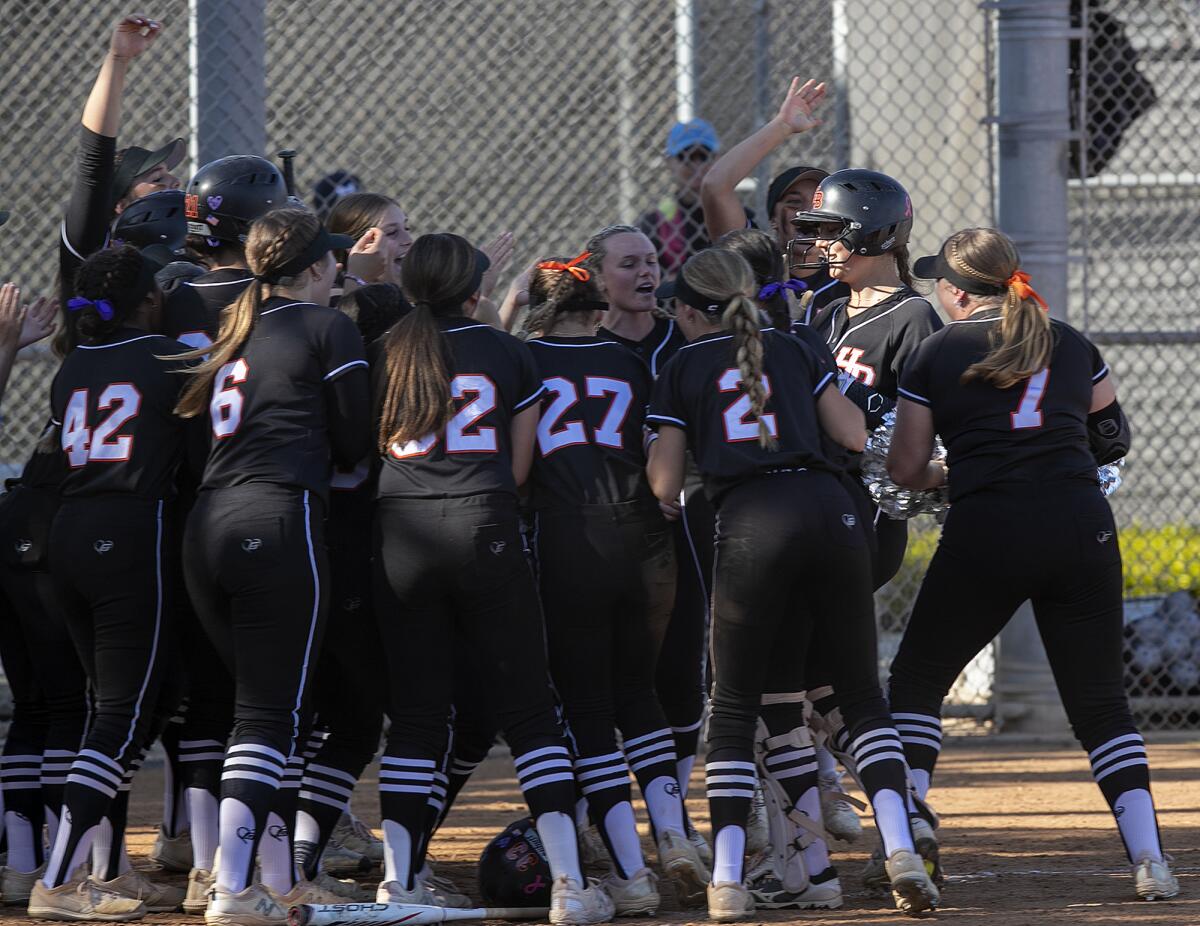 Huntington Beach's Zoe Prystajko is mobbed by her teammates after hitting a three-run home run in the fourth inning.