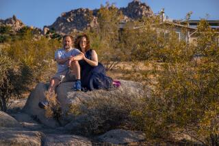 Colin Campbell and his wife Gail sitting on a rock in Joshua Tree.