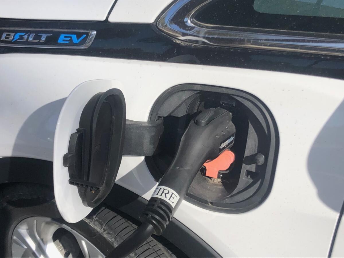 A charging plug inserted into an electric vehicle