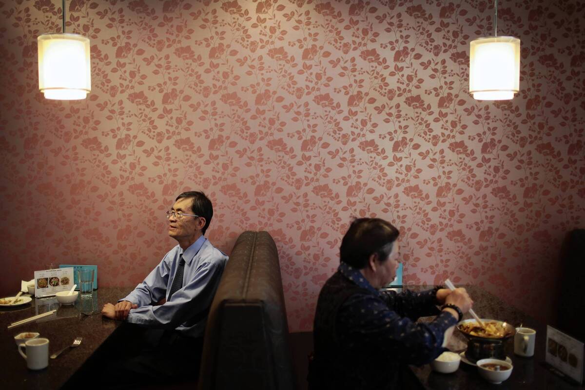 David Chan, left, knows Chinese food well, having documented eating in nearly 6,300 Chinese food restaurants. But he's never learned to use chopsticks. Above, he dines at Shawn Cafe in Arcadia.