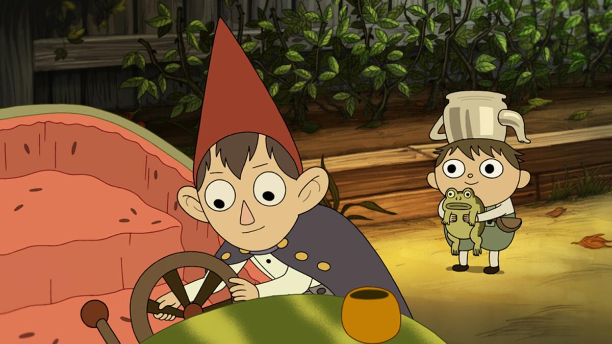 A character holding a frog watches another fiddle with the controls of a hollowed-out watermelon vehicle.