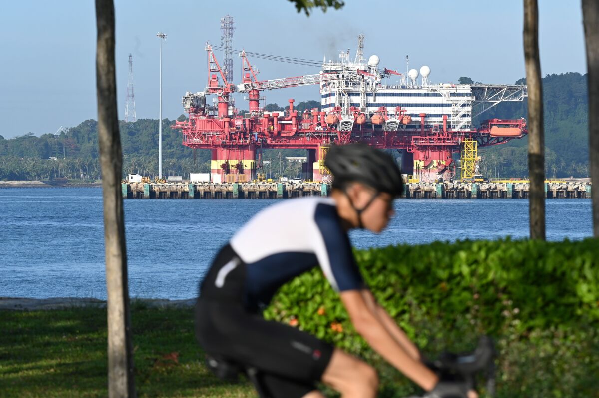 A floating construction support vessel, to be used as temporary housing for some healthy foreign workers, is docked at a port in Singapore.