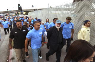 Father Greg Boyle, with glasses and a white beard, marches with program enrollees at Homeboy Industries to City Hall