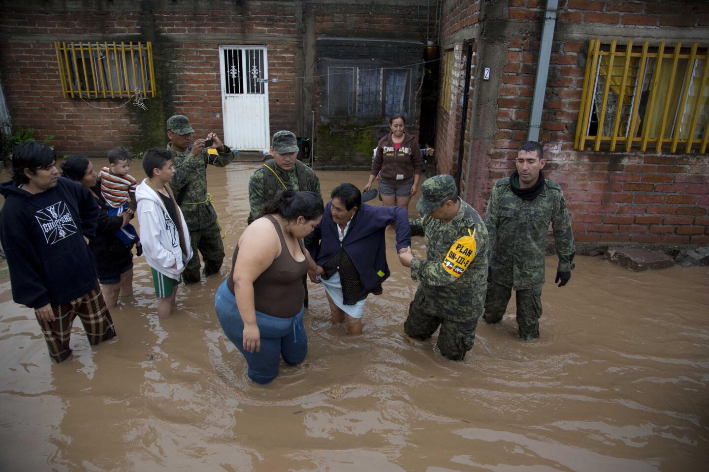 Soldiers help a woman leave her flooded house in Zoatlan, Nayarit state, northwest of Guadalajara, Mexico, on Oct. 24, 2015 the day after Hurricane Patricia made landfall.