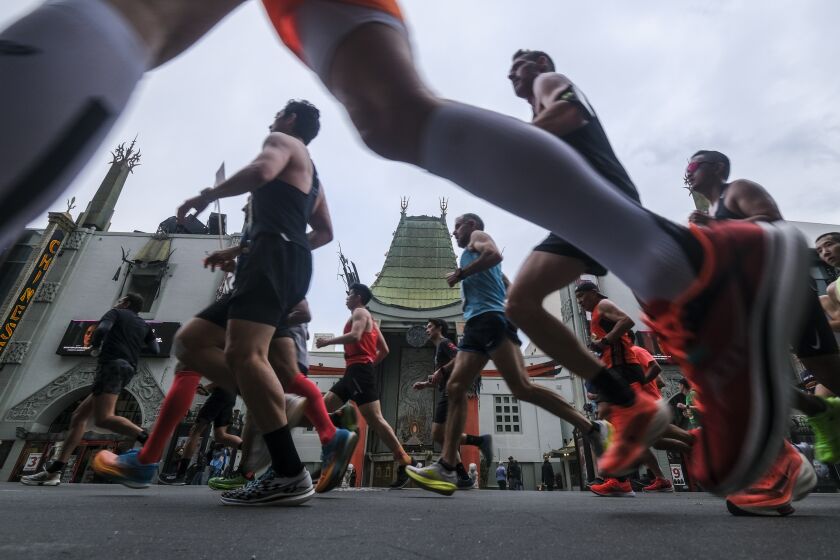 Runners run past TCL Chineses theater along Hollywood Boulevard during the 38th LA Marathon in Los Angeles, Sunday, March 19, 2023. (Photo by Ringo Chiu / For The Times)
