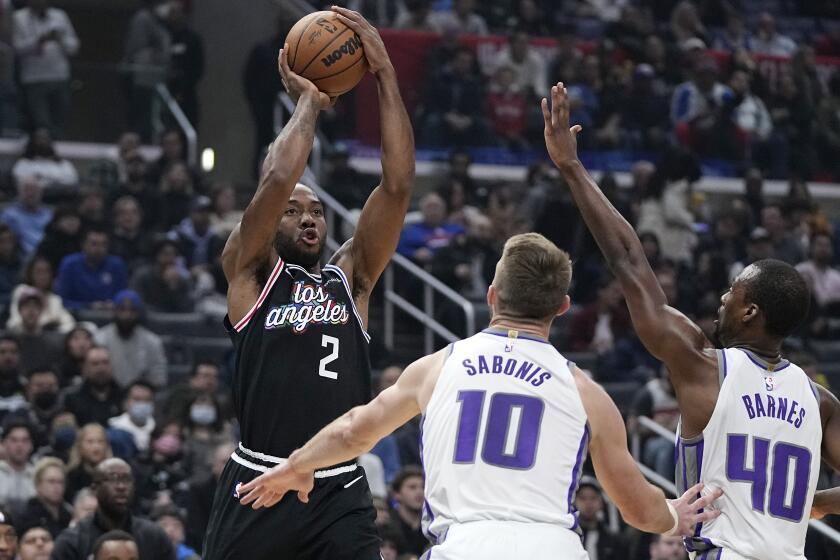Los Angeles Clippers forward Kawhi Leonard, left, shoots as Sacramento Kings forward Domantas Sabonis.