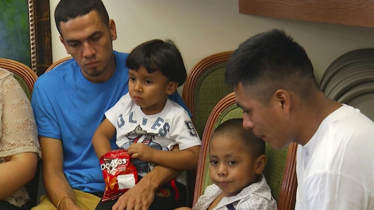 Javier Garrido Martinez, left, and Alan Garcia, right, sit with their 4-year-sons at a news conference in New York on Wednesday. The men were reunited with their children after almost two months of separation. Authorities took the children at the U.S. southern border.