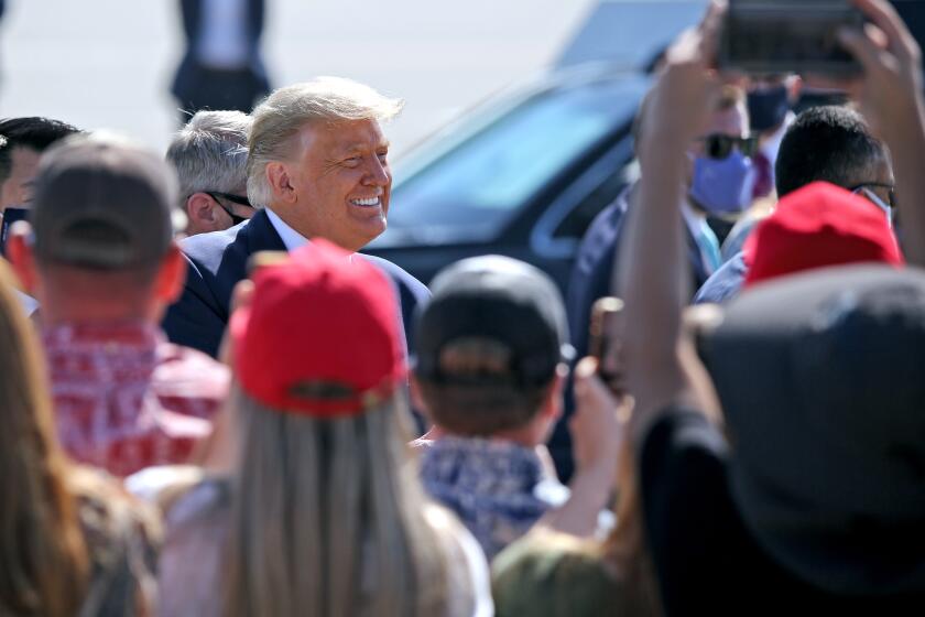 President Donald J. Trump greets supporters waiting for him on the tarmac at the John Wayne Airport, in Santa Ana on Sunday, Oct. 18, 2020. President Trump was in Orange County for a fundraiser in Newport Beach.