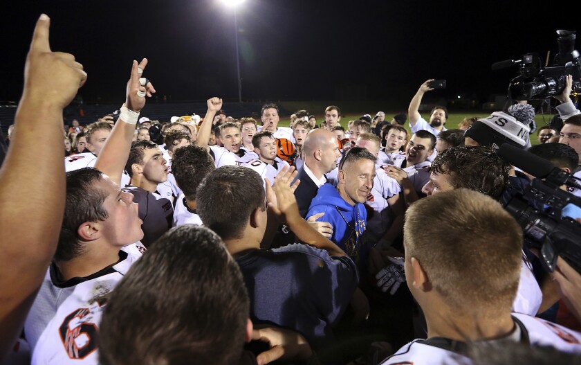 Bremerton assistant football coach Joe Kennedy amid players