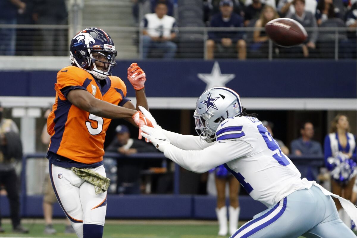 Denver Broncos quarterback Teddy Bridgewater (5) throws a pass under pressure from Dallas Cowboys defensive end Randy Gregory in the first half of an NFL football game in Arlington, Texas, Sunday, Nov. 7, 2021. (AP Photo/Roger Steinman)