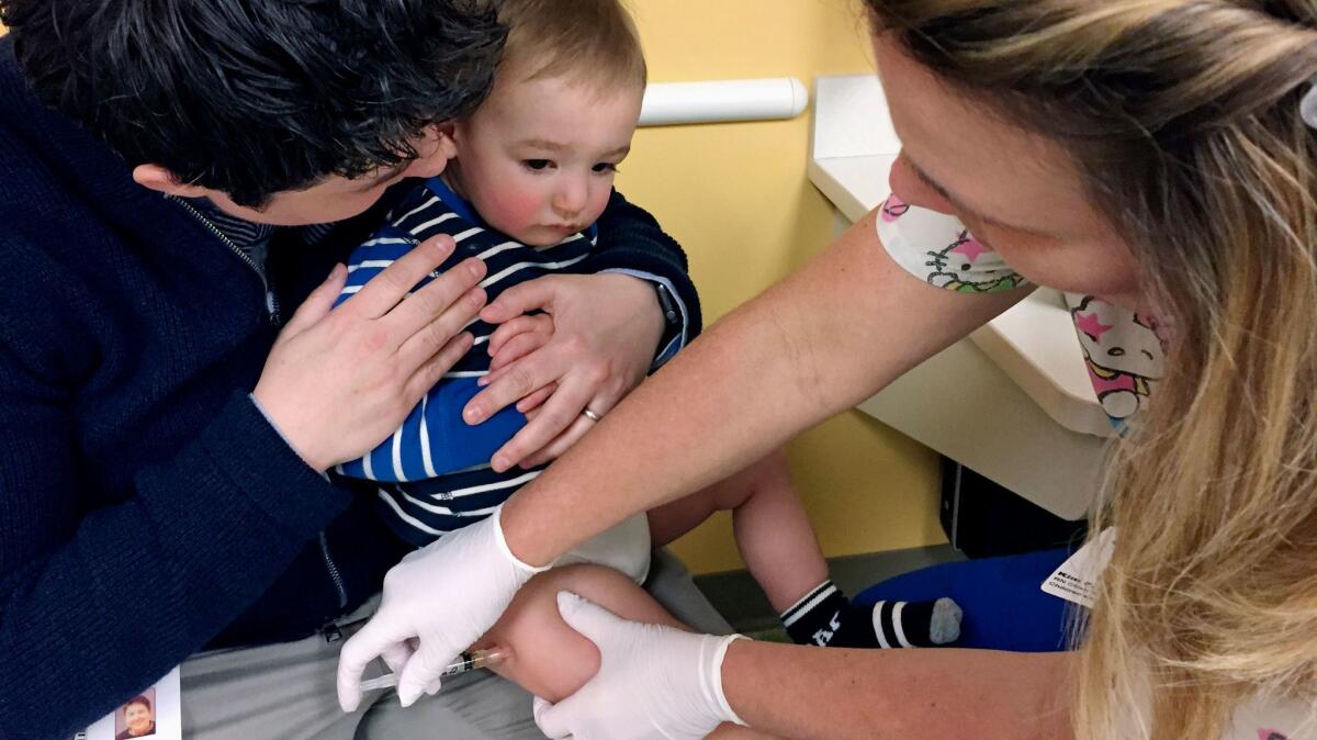 A child receives a measles/mumps/rubella shot in Minnesota, a state currently facing a serious measles outbreak. Republican policies would threaten the health coverage of millions of children nationwide.