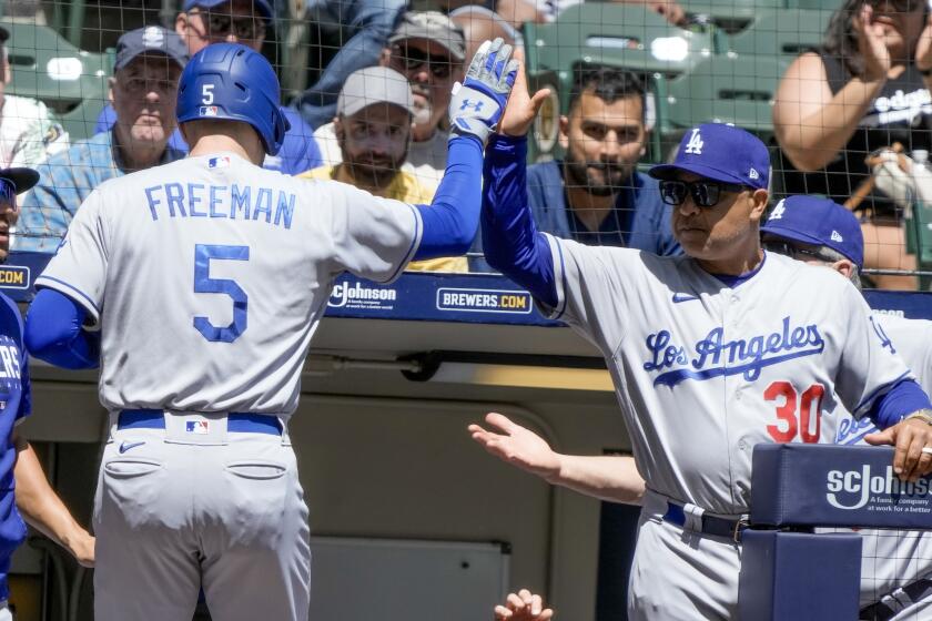Los Angeles Dodgers' Freddie Freeman is congratulated by manager Dave Roberts after hitting a home run during the fourth inning of a baseball game against the Milwaukee Brewers Wednesday, May 10, 2023, in Milwaukee. (AP Photo/Morry Gash)