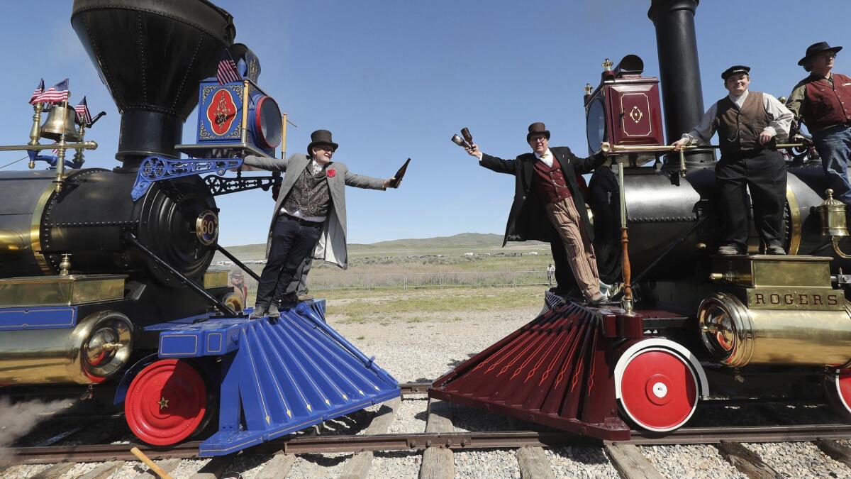Doug Foxley, left, and Spencer Stokes re-create a historic photo at the Golden Spike National Historical Park in Promontory, Utah, on Friday.