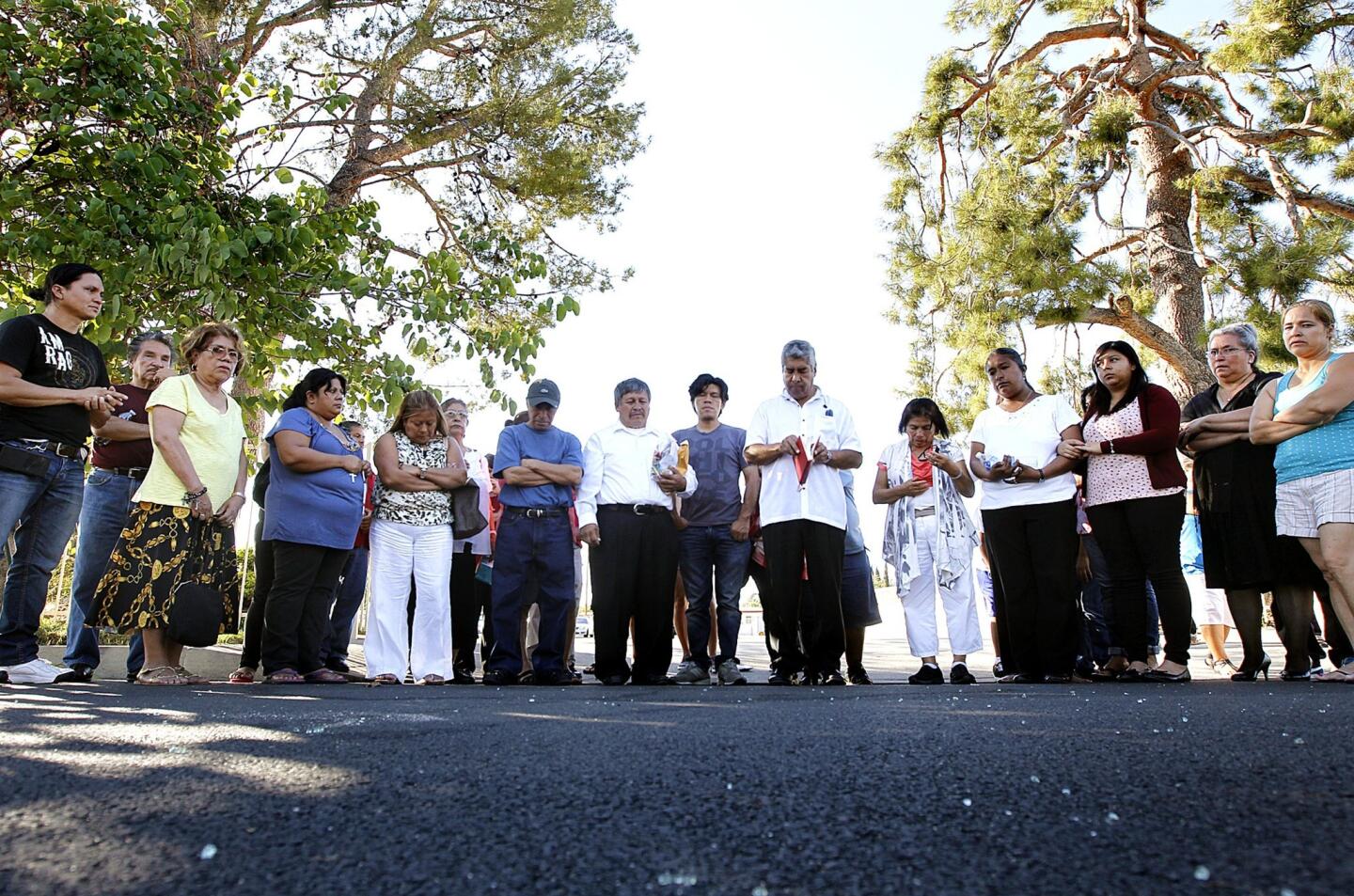 Members of Guardian Angel Parish in Pacoima gather in prayer at the site where a fellow church member, a woman, was shot and killed on Filmore Street in Pacoima.