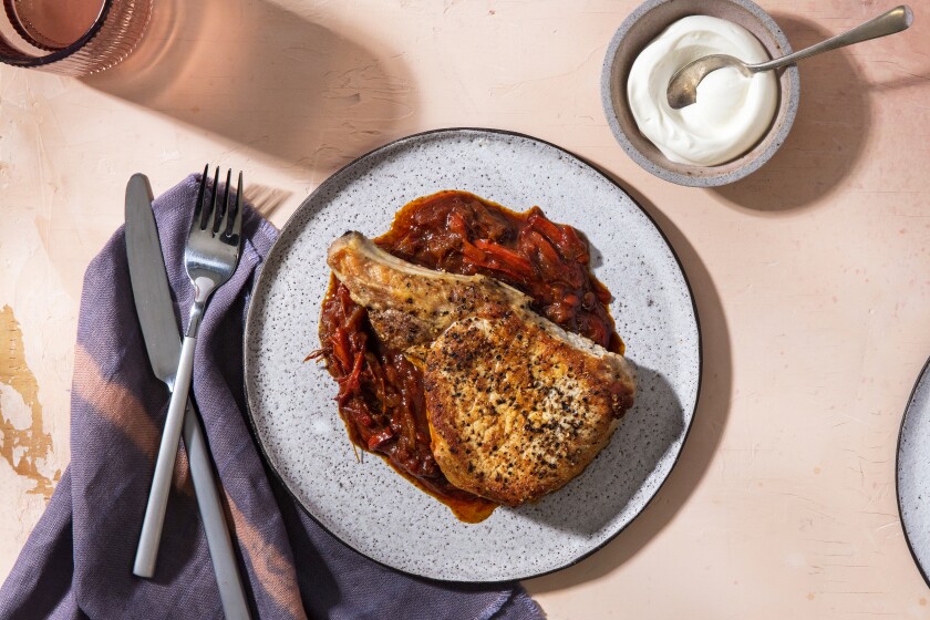 Thick-cut pork chops are served atop a brick-red sauce of peppers and paprika in this restaurant-style spin on the classic Eastern European dish paprikash.