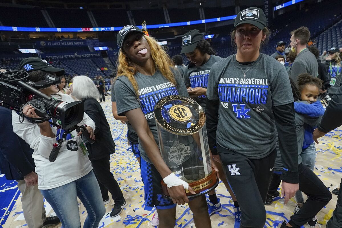 Kentucky's Rhyne Howard carries the trophy after Kentucky beat South Carolina in the NCAA women's college basketball Southeastern Conference tournament championship game Sunday, March 6, 2022, in Nashville, Tenn. (AP Photo/Mark Humphrey)