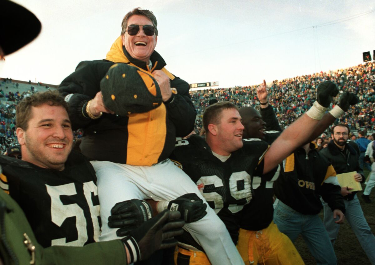 In this Nov. 20, 1993, file photo, Iowa football coach Hayden Fry is carried off the field after his team defeated Minnesota, giving him his 200th career victory in Iowa City, Iowa.