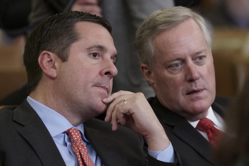 File - In this Dec. 2019 file photo, Rep. Devin Nunes, R-Calif, left, the ranking member of the House Intelligence Committee, speaks with then Rep. Mark Meadows, R-N.C., a member of the House Committee on Oversight and Reform, as they sit in the audience as the House Judiciary Committee holds a hearing on the constitutional grounds for the president's impeachment, on Capitol Hill in Washington. President Donald Trump is set to present one of the nation's highest civilian honors to Nunes. (AP Photo/J. Scott Applewhite)