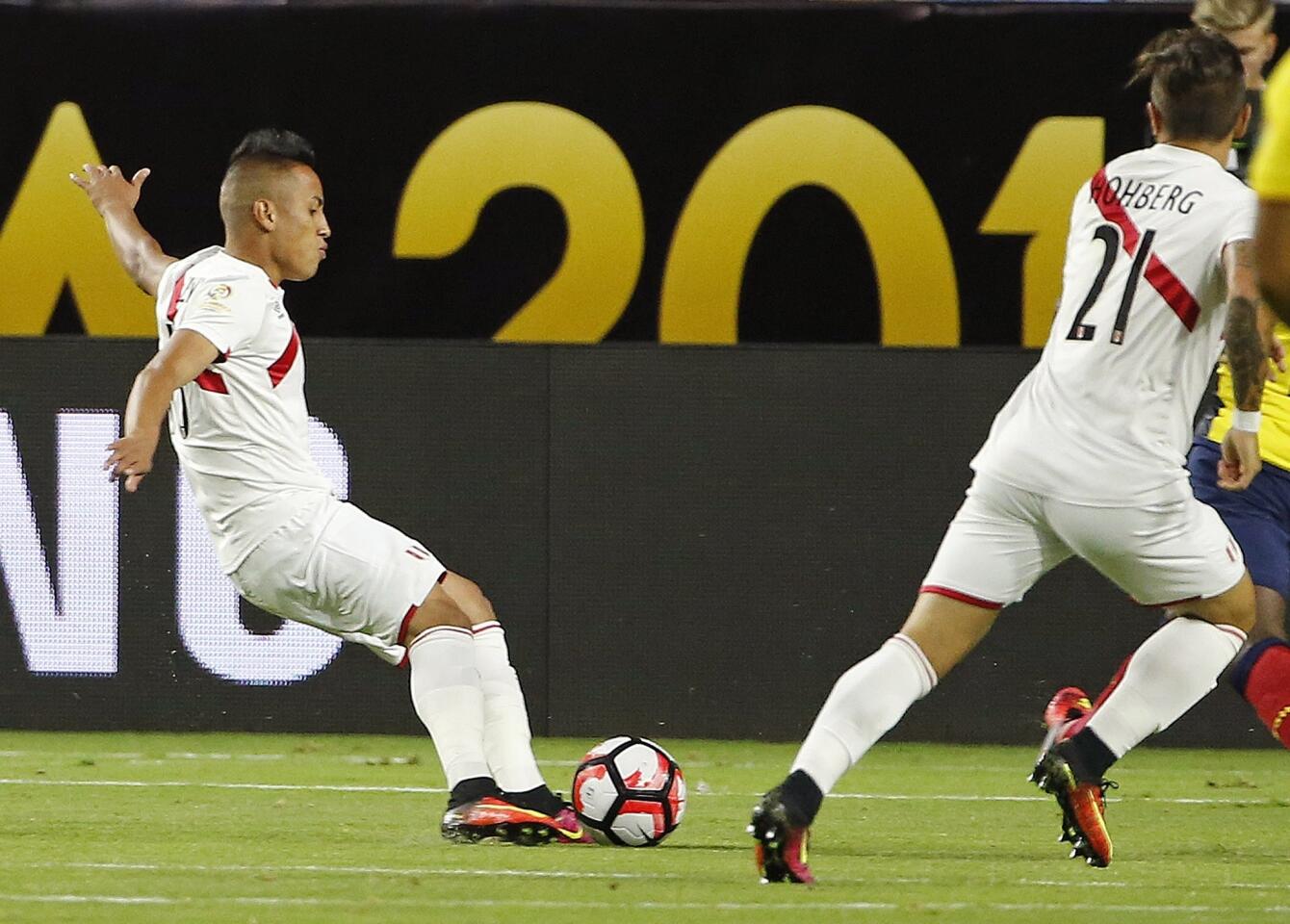 Peru's Christian Cueva, left, kicks the ball for a goal as teammate Alejandro Hohberg (21) watches during the first half of a Copa America group C soccer match against Ecuador on Wednesday, June 8, 2016, in Glendale, Ariz. (AP Photo/Ross D. Franklin)