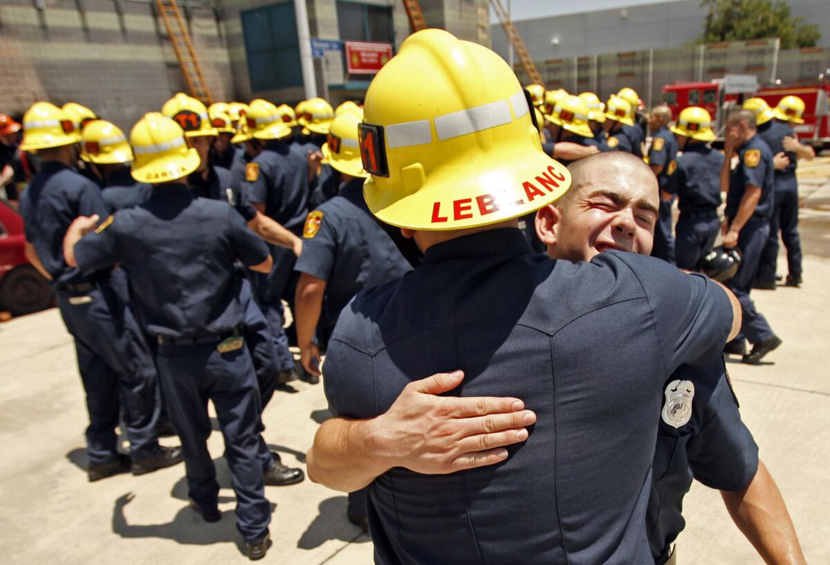 Daniel Balzano, right, gets a hug from Matthew LeBlanc as 58 recruits of the Los Angeles Fire Department celebrate following the recruit graduation ceremony on June 12. More than 10,000 applicants have applied for the next round of LAFD hiring.