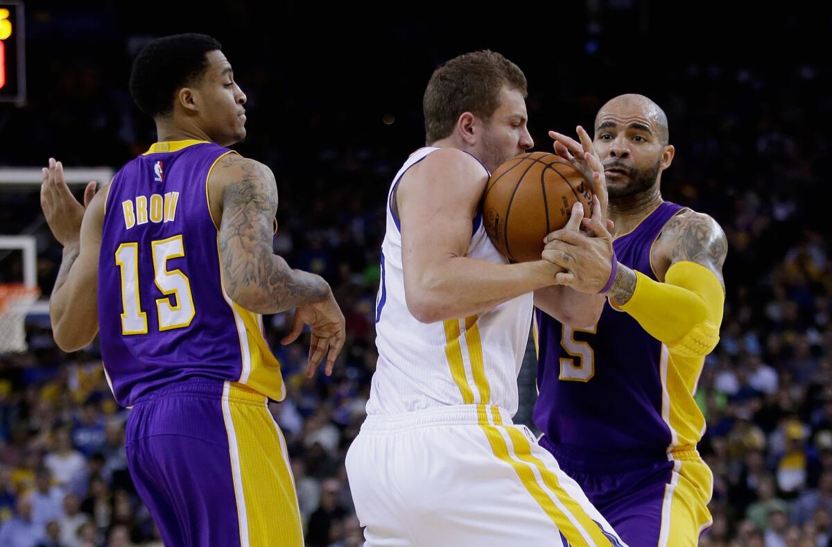 Warriors forward David Lee steals the ball from Lakers power forward Carlos Boozer (5) while Jabari Brown (15) looks on in the first half.