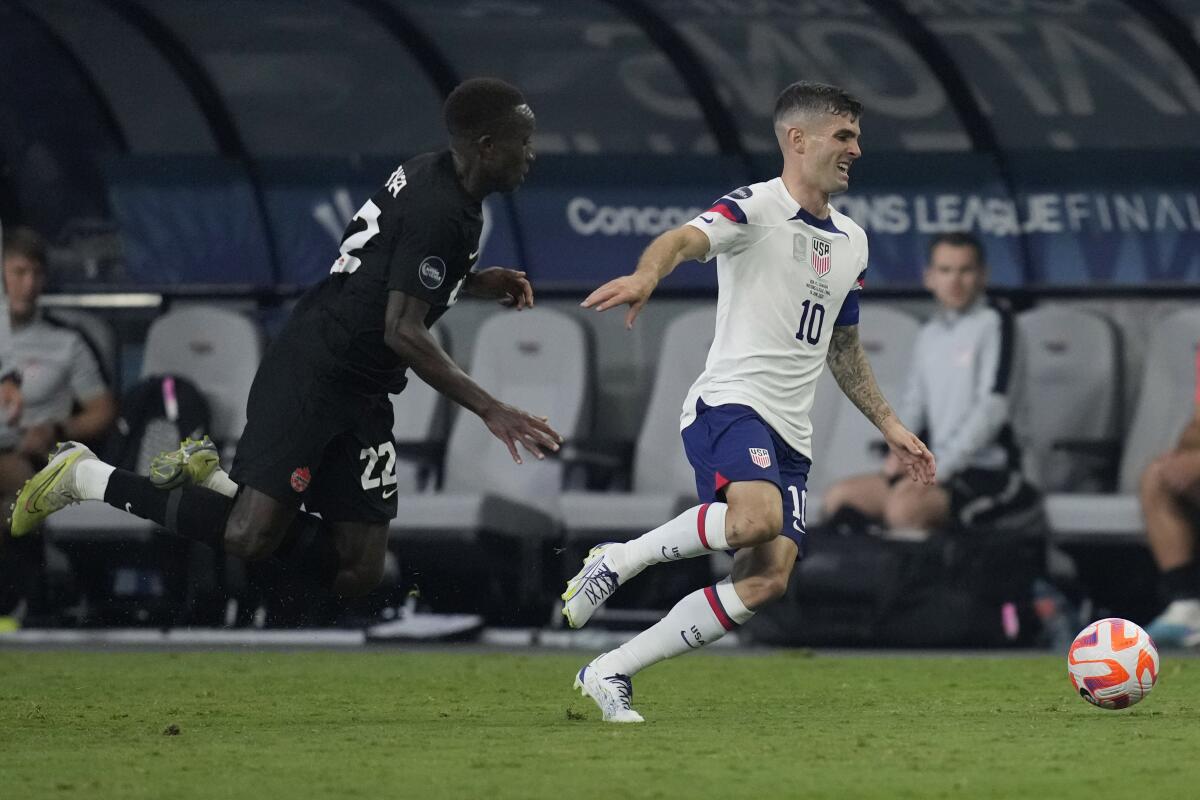 U.S. forward Christian Pulisic controls the ball in front of Canada's Richmond Laryea during the first half Sunday.
