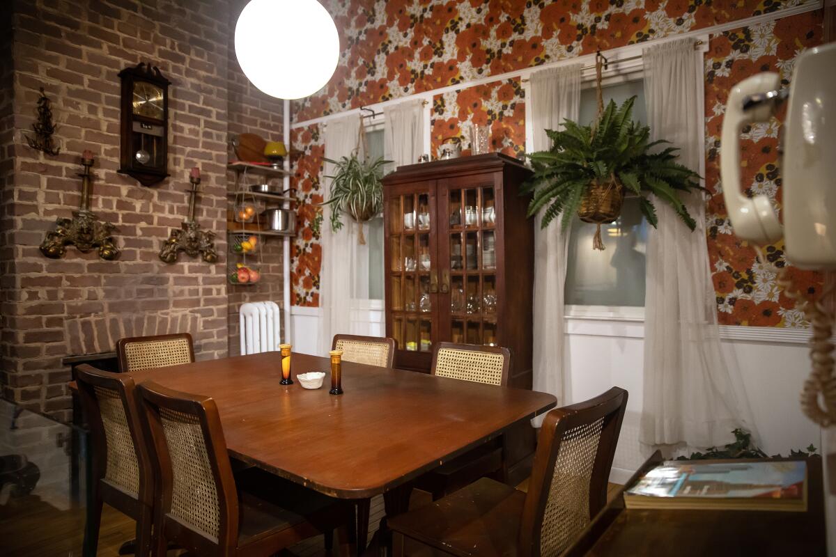 A dining room with brick and wallpapered walls.