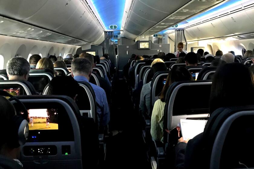 MAR. 5, 2018 - Main cabin passengers pass the time aboard American Airlines flight 2331, a Boeing 787-800 Dreamliner, an route from Chicago O'Hare International Airport to Dallas/Fort Worth International Airport, on Mar. 5, 2018. (Jerome Adamstein / Los Angeles Times)