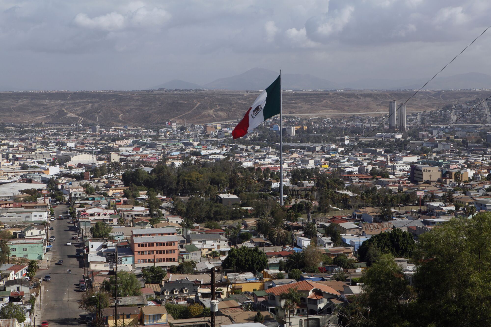 A large Mexican flag flies above downtown Tijuana.