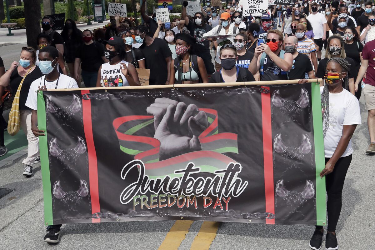  In this June 19, 2020, file photo, demonstrators march through downtown Orlando, Fla., during a Juneteenth event. 