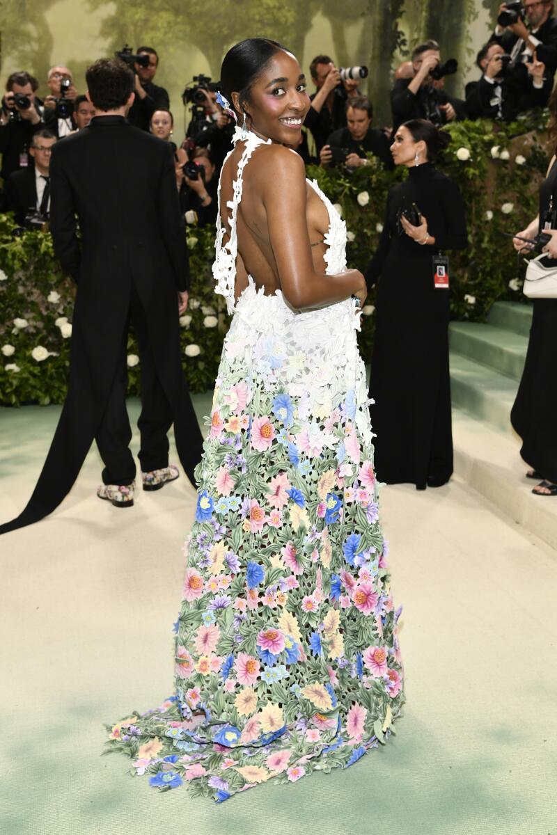 Ayo Edebiri blooms in a backless, floor-length sweep of floral embellishment, designed by Jonathan Anderson for Loewe.