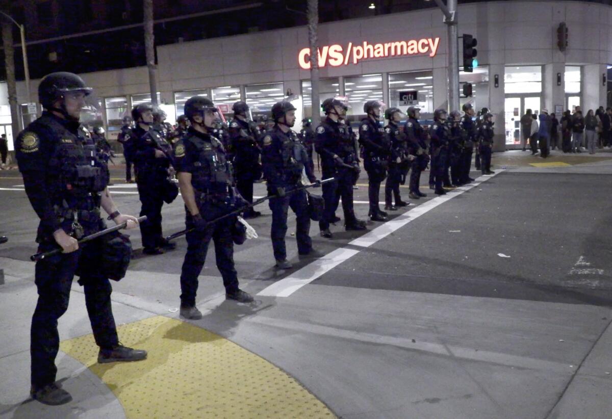 Police set up containment lines near the Huntington Beach Pier after calling an unlawful assembly.