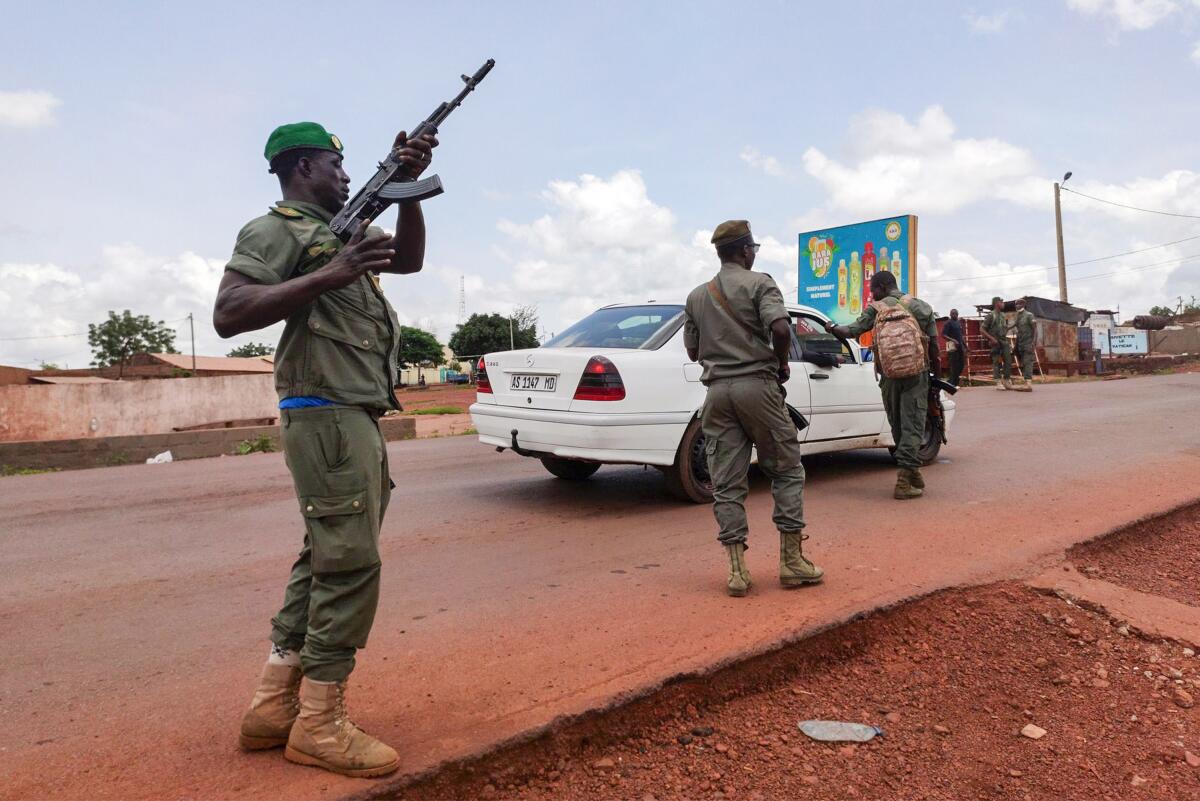 Malian soldiers check a vehicle in the garrison town of Kati, Mali.