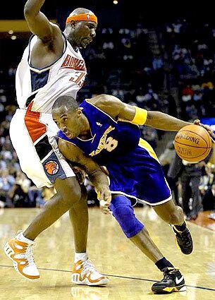 COMING THROUGH: Kobe Bryant lowers his shoulder and heads toward the basket as Charlotte's Jumaine Jones provides defensive pressure.