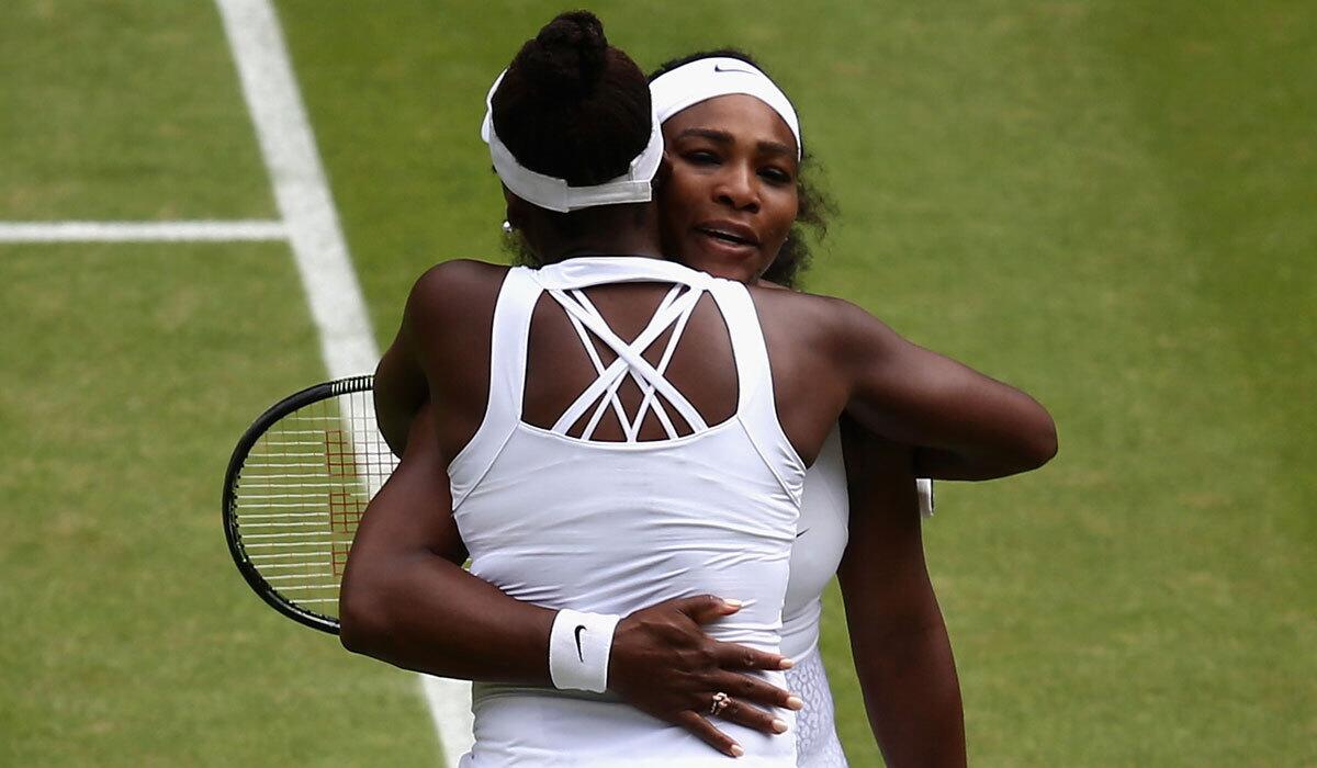 Sisters Serena, right, and Venus Williams embrace Monday after their match at Wimbledon.