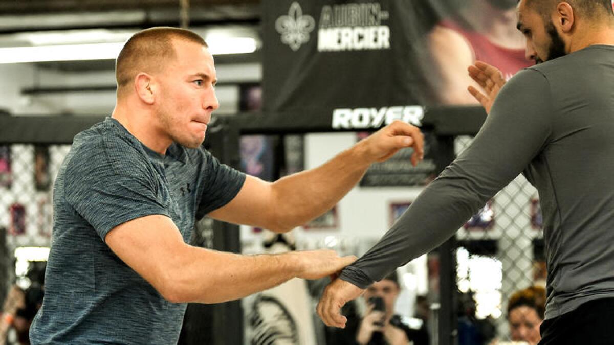 Georges St-Pierre, left, trains with Firas Zahabi during a workout for the media on Oct. 25.
