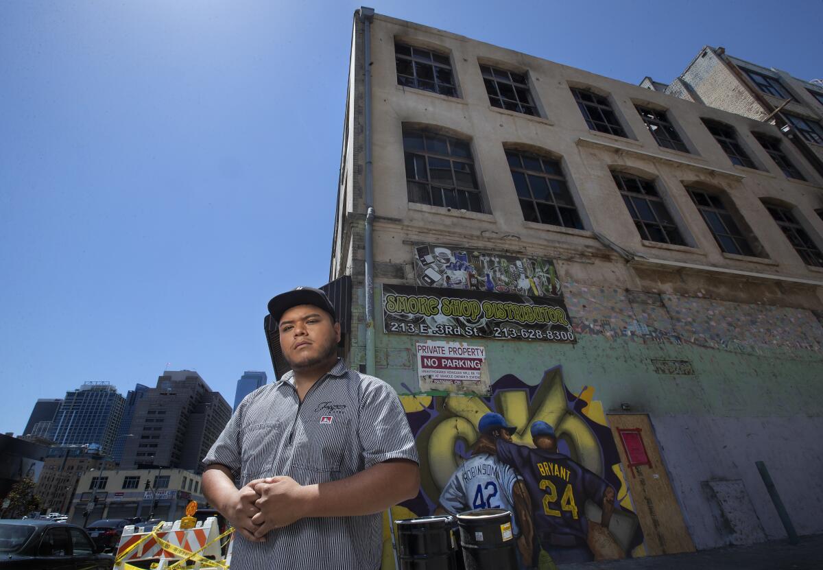 Jesse Fregozo stands in front of a mural of Jackie Robinson and Kobe Bryant