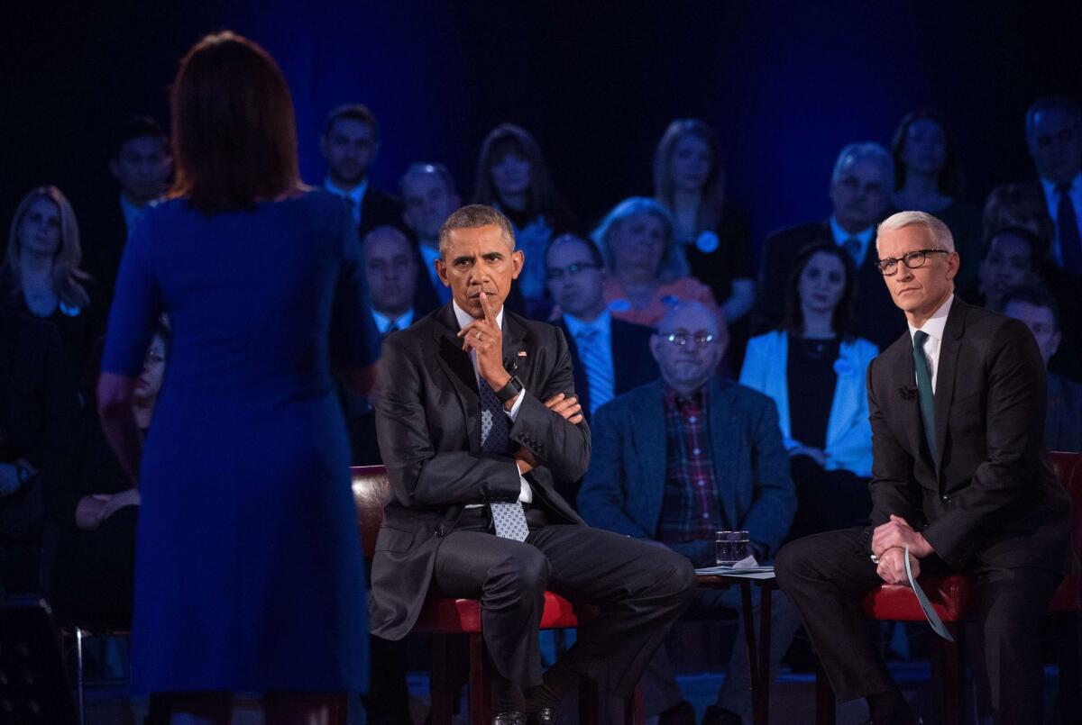 President Obama takes a question at a town hall meeting at George Mason University in Fairfax, Va., on reducing gun violence, as CNN's Anderson Cooper looks on.